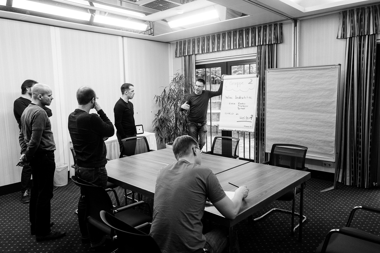 Schwarz-weiß Foto des mtc Teams in Diskussion